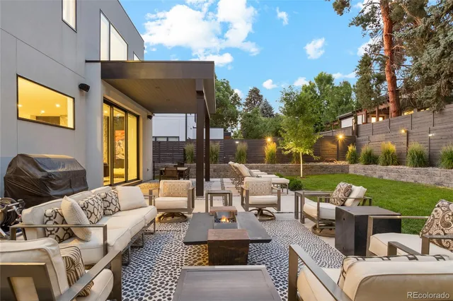 a view of a patio with couches potted plants and a big yard