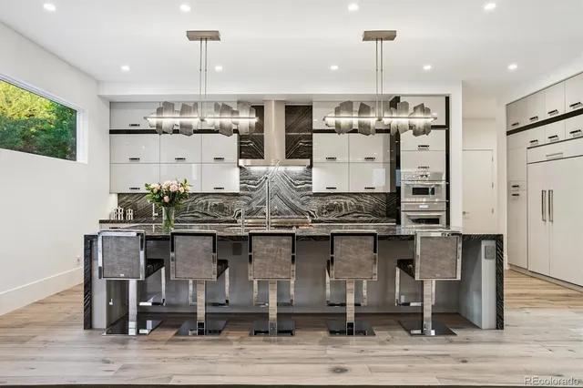 a kitchen with stainless steel appliances kitchen island a chandelier and refrigerator