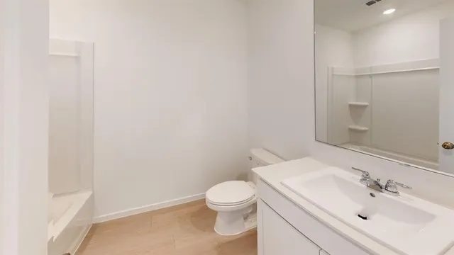 a bathroom with a sink a toilet and a mirror