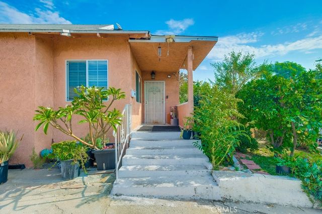 a view of a entryway door with potted plants in front of house