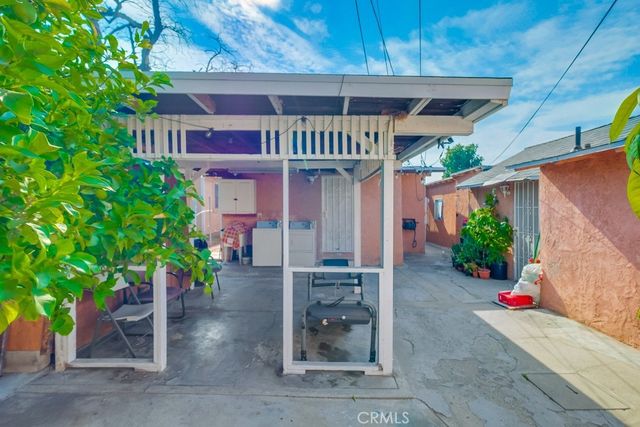 a front view of a house with a yard and potted plants