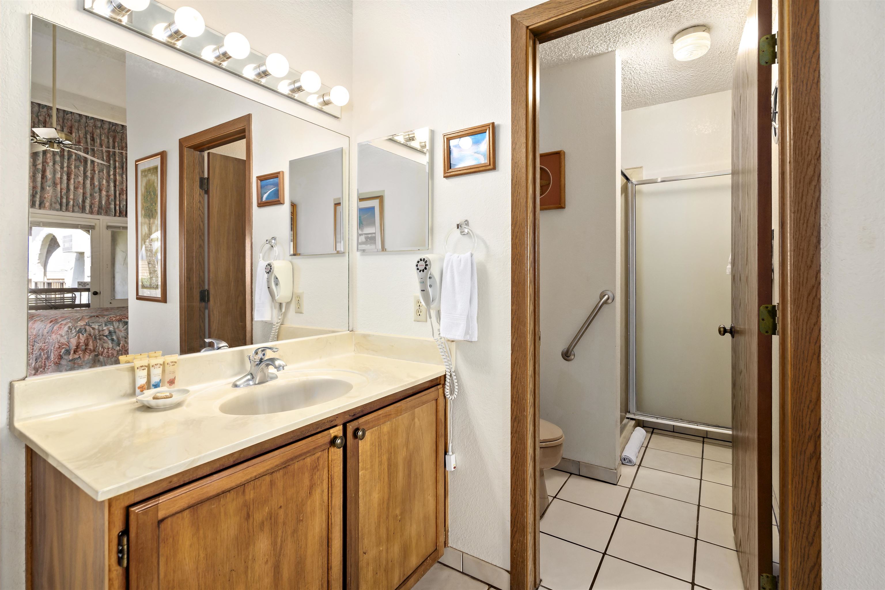 2881 South Kihei Road, Unit 100 Kihei, HI 96753 - Photo 13 of 32 a bathroom with a sink a mirror and a shower