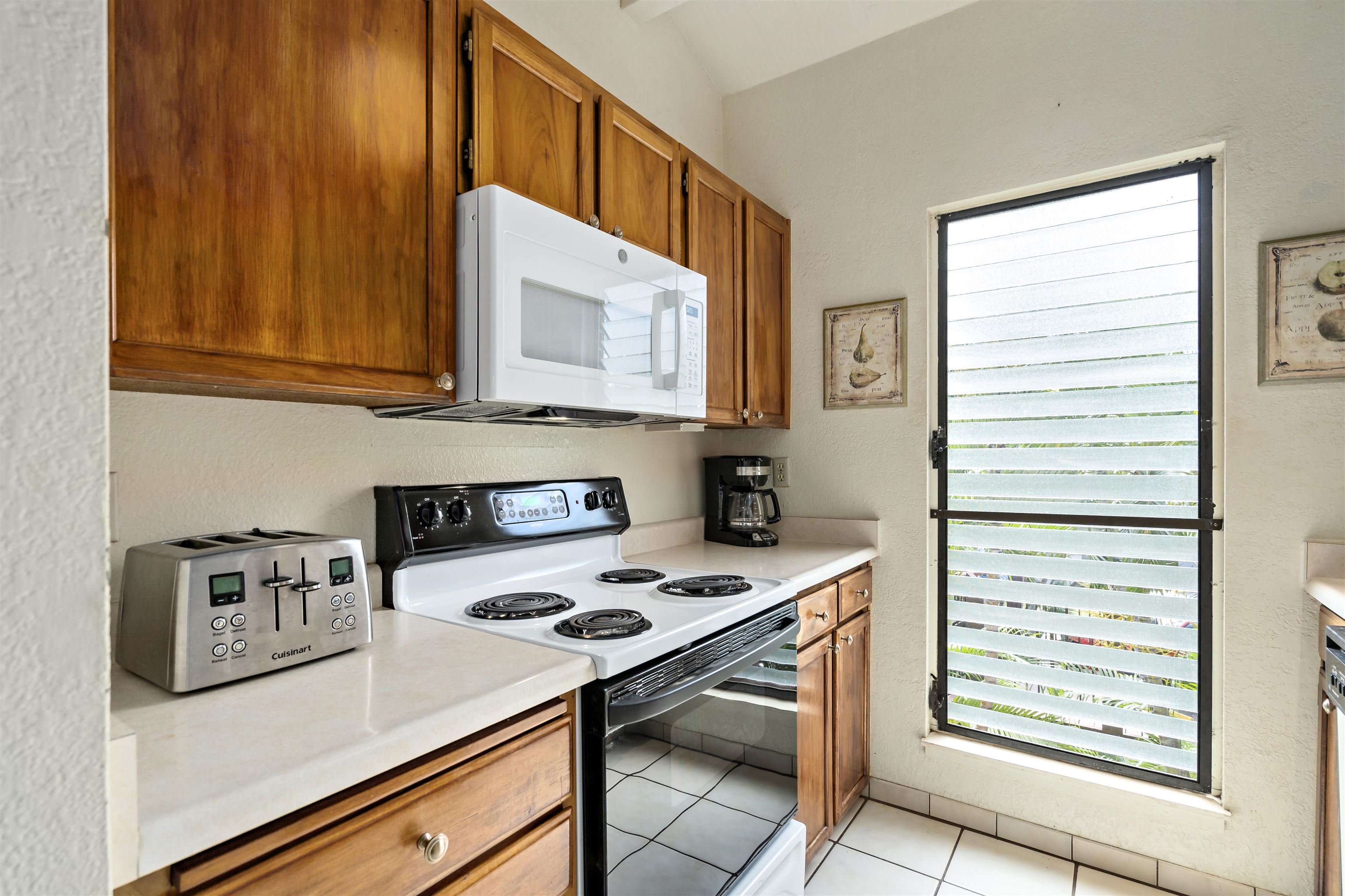 2881 South Kihei Road, Unit 100 Kihei, HI 96753 - Photo 19 of 32 a kitchen with a stove and a microwave