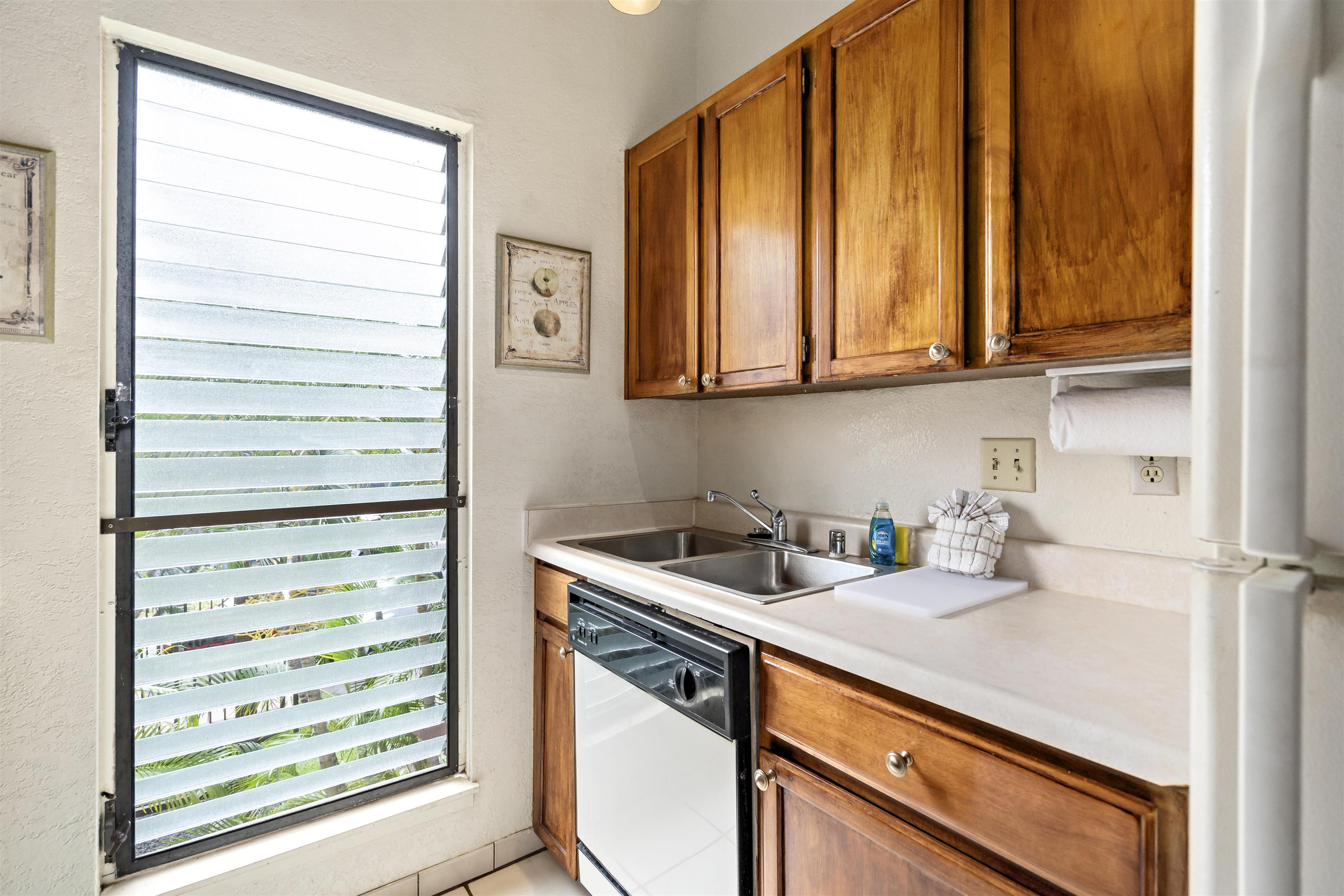 2881 South Kihei Road, Unit 100 Kihei, HI 96753 - Photo 20 of 32 a kitchen with appliances cabinets and a window