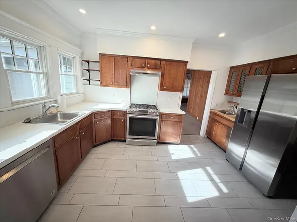 a large kitchen with stainless steel appliances granite countertop a sink and cabinets