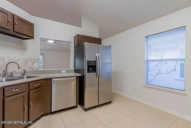 a kitchen with stainless steel appliances granite countertop a refrigerator and a sink