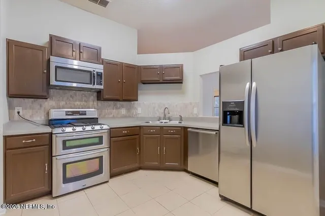 a kitchen with stainless steel appliances granite countertop a refrigerator stove and sink