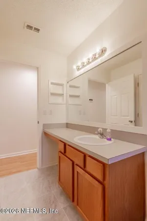 a bathroom with a sink vanity and mirror
