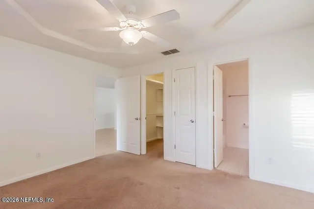 an empty room with a ceiling fan and a window