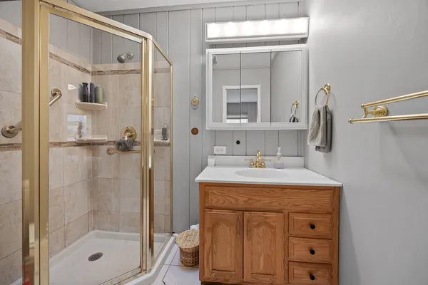 a bathroom with a shower sink vanity and mirror