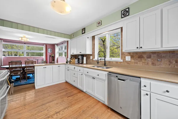 a large kitchen with stainless steel appliances granite countertop a lot of counter space and wooden floors