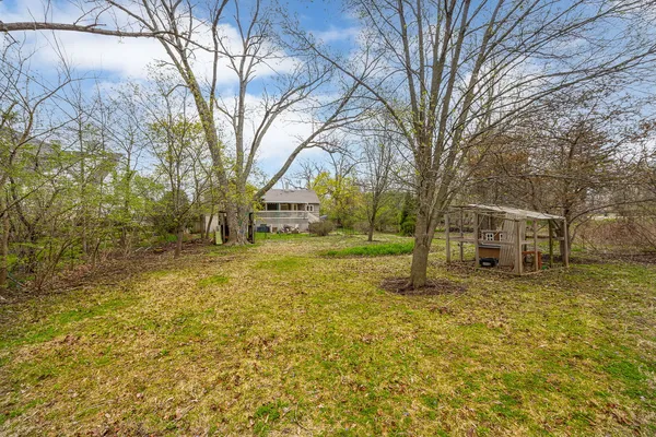 a view of a yard with a house and large trees