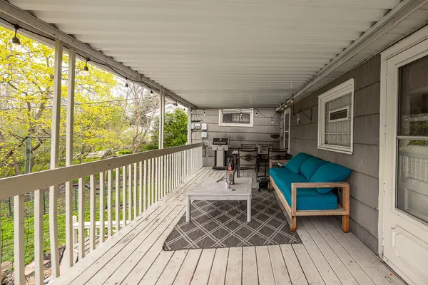 a balcony with wooden floor outdoor seating and wooden floor