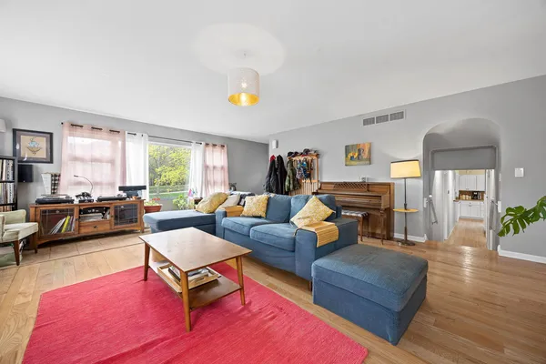 a living room with furniture and a wooden floor