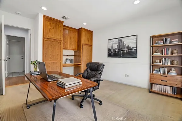 a view of a workspace with furniture and a window