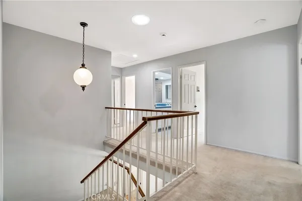 a view of staircase with railing and a chandelier