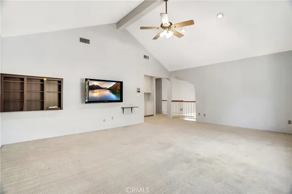 an empty room with windows and fireplace