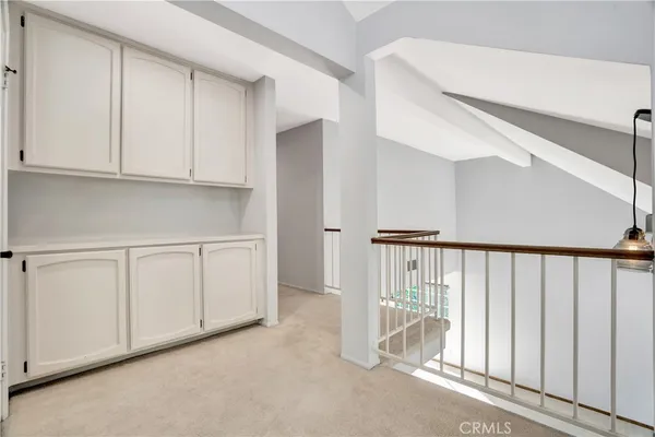a view of a hallway with white cabinets