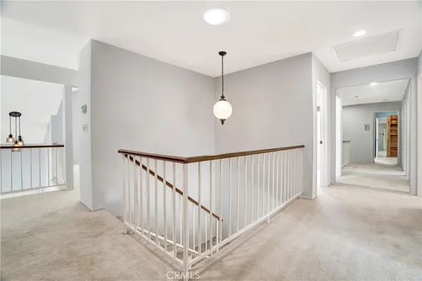 a view of a hallway with a chandelier fan