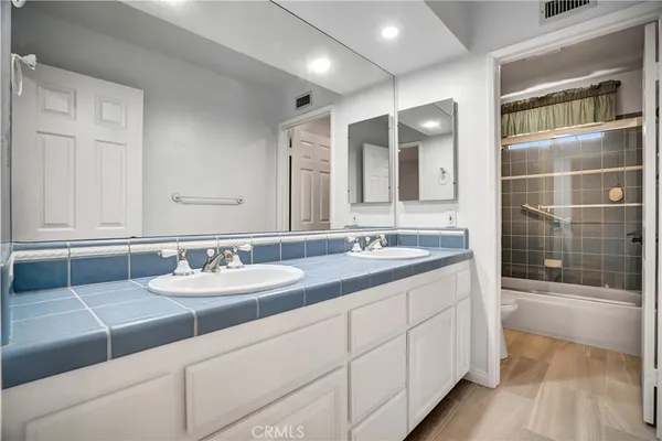 a bathroom with a double vanity sink and a mirror