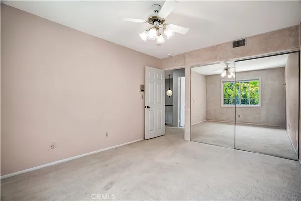 an empty room with windows and fan