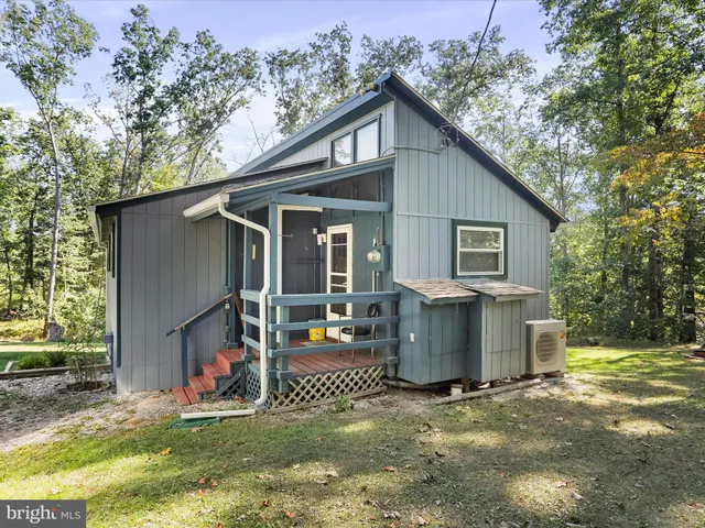 a view of a house with backyard and a tree