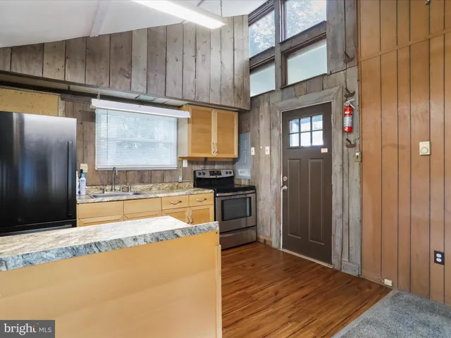 a kitchen with stainless steel appliances granite countertop a refrigerator and a stove