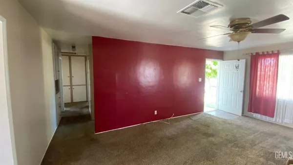 an empty room with windows and fan