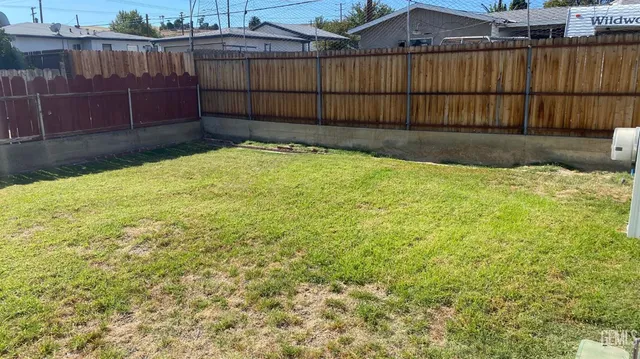 a view of backyard with wooden fence