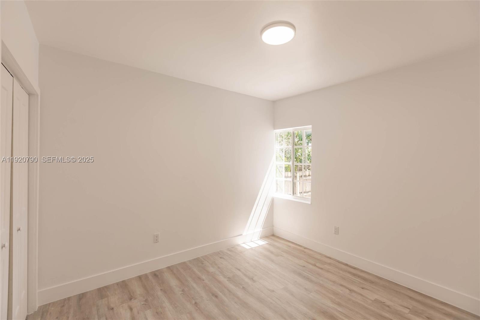 3180 Northwest 2nd Street Miami, FL 33125 - Photo 11 of 29 an empty room with wooden floor and windows