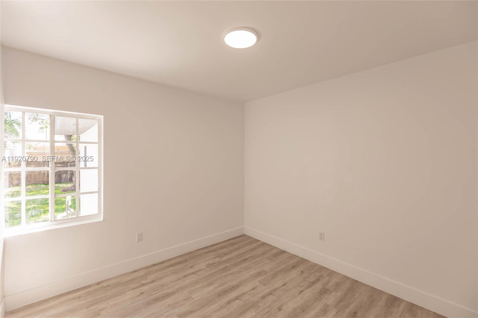 3180 Northwest 2nd Street Miami, FL 33125 - Photo 13 of 29 an empty room with wooden floor and windows