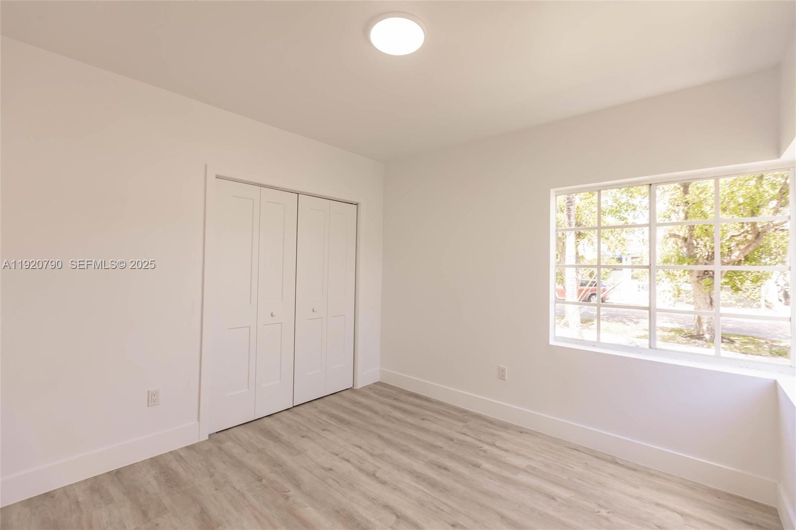 3180 Northwest 2nd Street Miami, FL 33125 - Photo 16 of 29 an empty room with wooden floor and windows