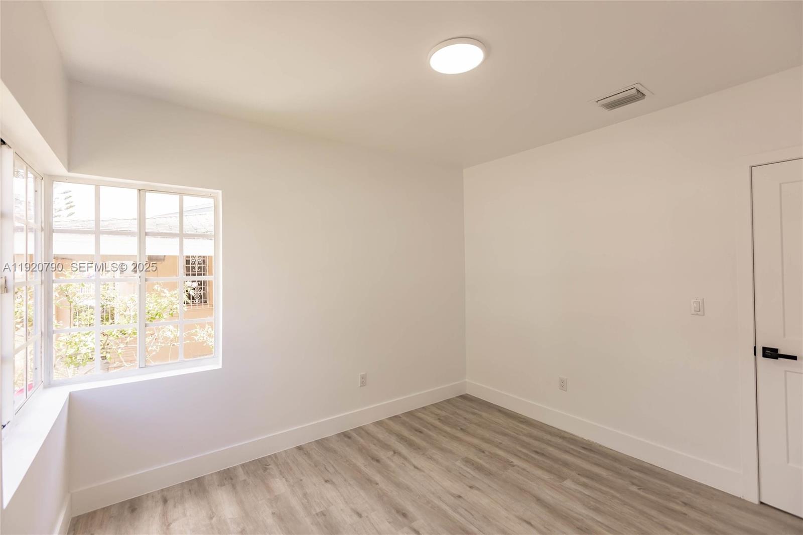 3180 Northwest 2nd Street Miami, FL 33125 - Photo 17 of 29 an empty room with wooden floor and windows
