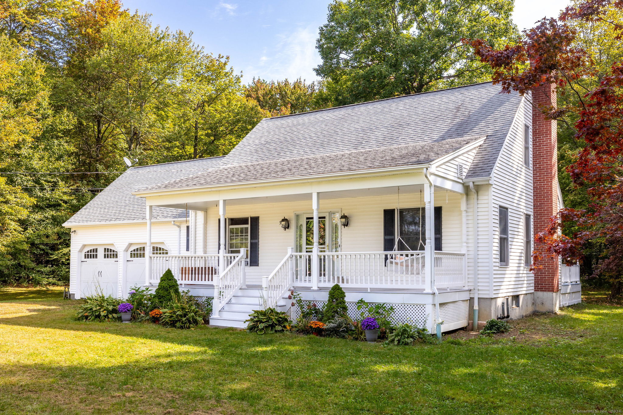 a front view of a house with a garden and trees