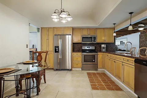 a kitchen with stainless steel appliances granite countertop a refrigerator stove and cabinets