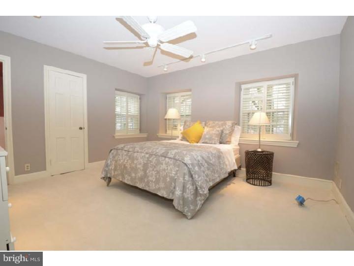 245 Mcclenaghan Mill Road Wynnewood, PA 19096 - Photo 14 of 22 a bedroom with a large bed and a chandelier
