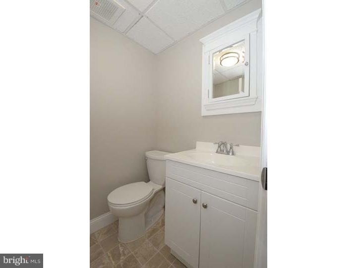 245 Mcclenaghan Mill Road Wynnewood, PA 19096 - Photo 17 of 22 a bathroom with a granite countertop toilet a sink and mirror