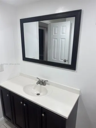 a bathroom with a sink vanity and mirror