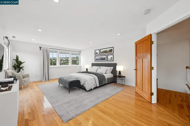 a spacious bedroom with a bed and wooden floor