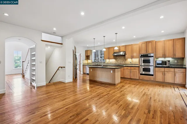 a kitchen with stainless steel appliances wooden floors and wooden cabinets