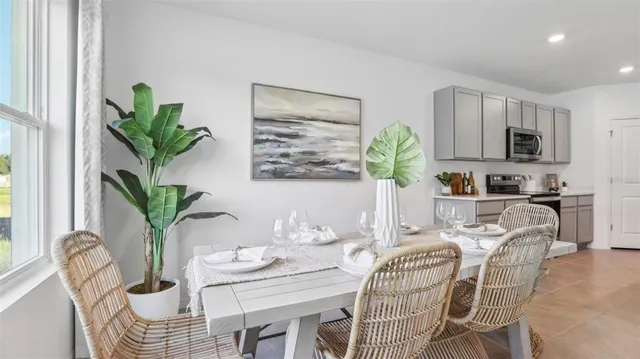a living room with furniture a potted plant and a kitchen view