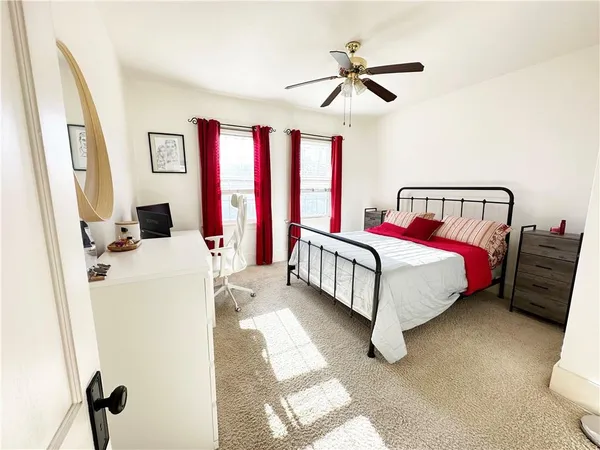 a bed room with a bed window and a ceiling fan