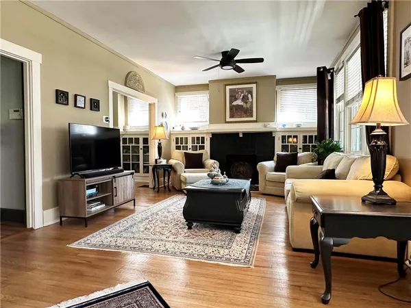 a living room with furniture a flat screen tv and a table