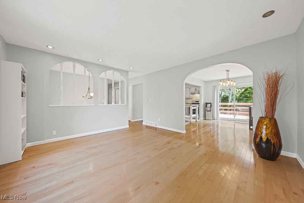17682 Drake Road Strongsville, OH 44136 - Photo 7 of 45 Unfurnished living room featuring a chandelier, arched walkways, light wood finished floors, and recessed lighting