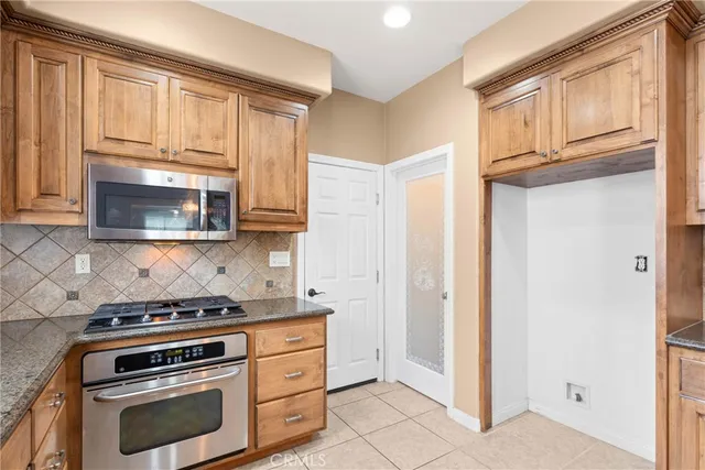 a kitchen with granite countertop white cabinets and appliances