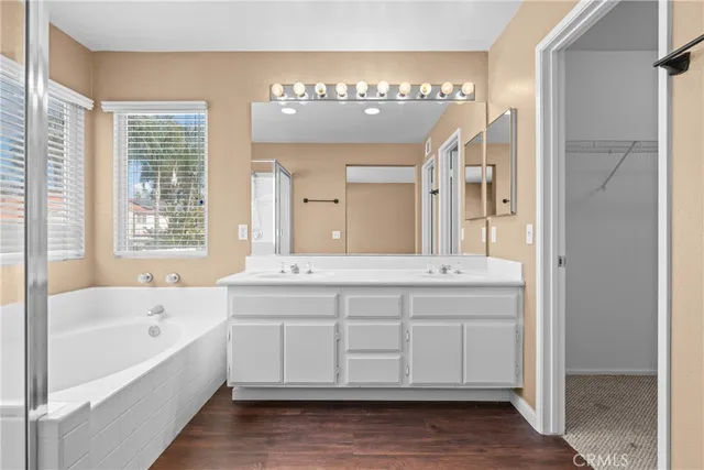 a spacious bathroom with a tub sink and mirror