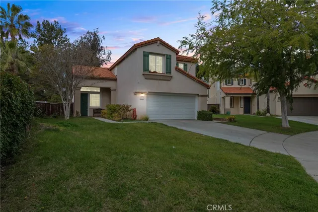 a front view of a house with a garden and yard