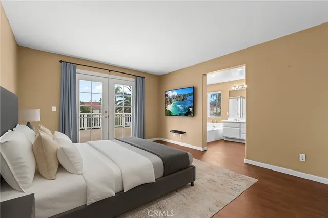 a bedroom with a large bed and a wooden floor
