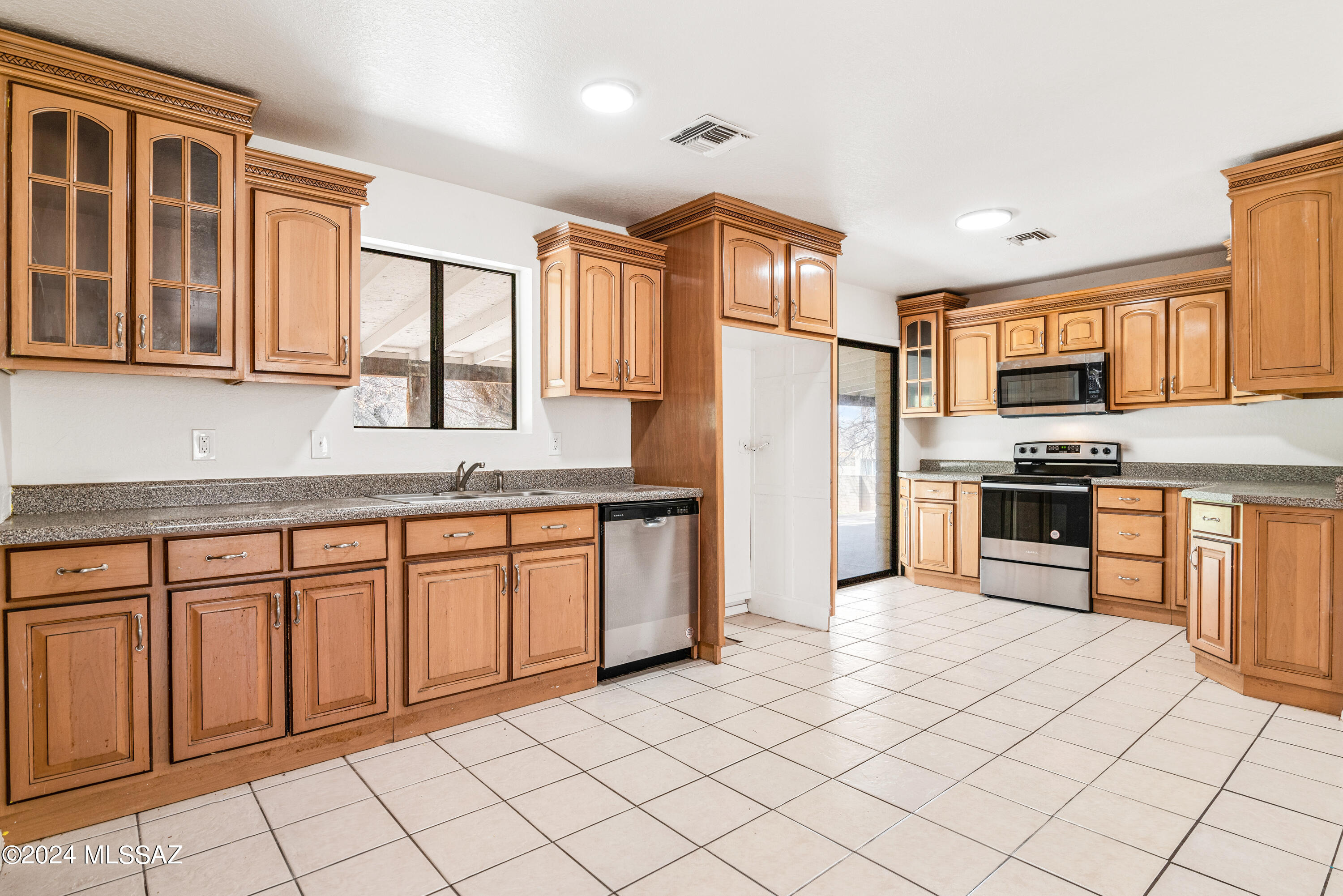 273 Harpo Court Rio Rico, AZ 85648 - Photo 1 of 34 a kitchen with stainless steel appliances granite countertop a refrigerator and wooden cabinets