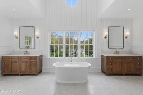a spacious bathroom with a double vanity sink tub and mirror